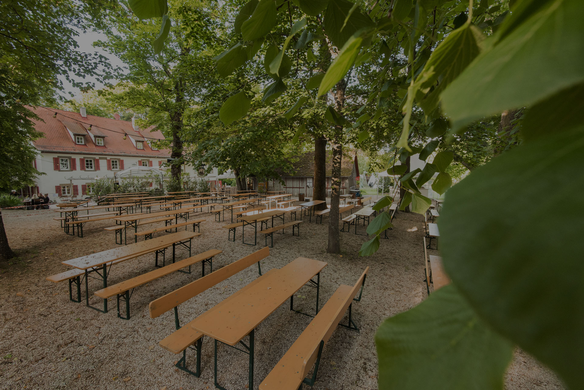 Biergarten Einkorn, Bierbänke und Tische im Hintergrund das Gasthaus Einkorn mit Restaurant