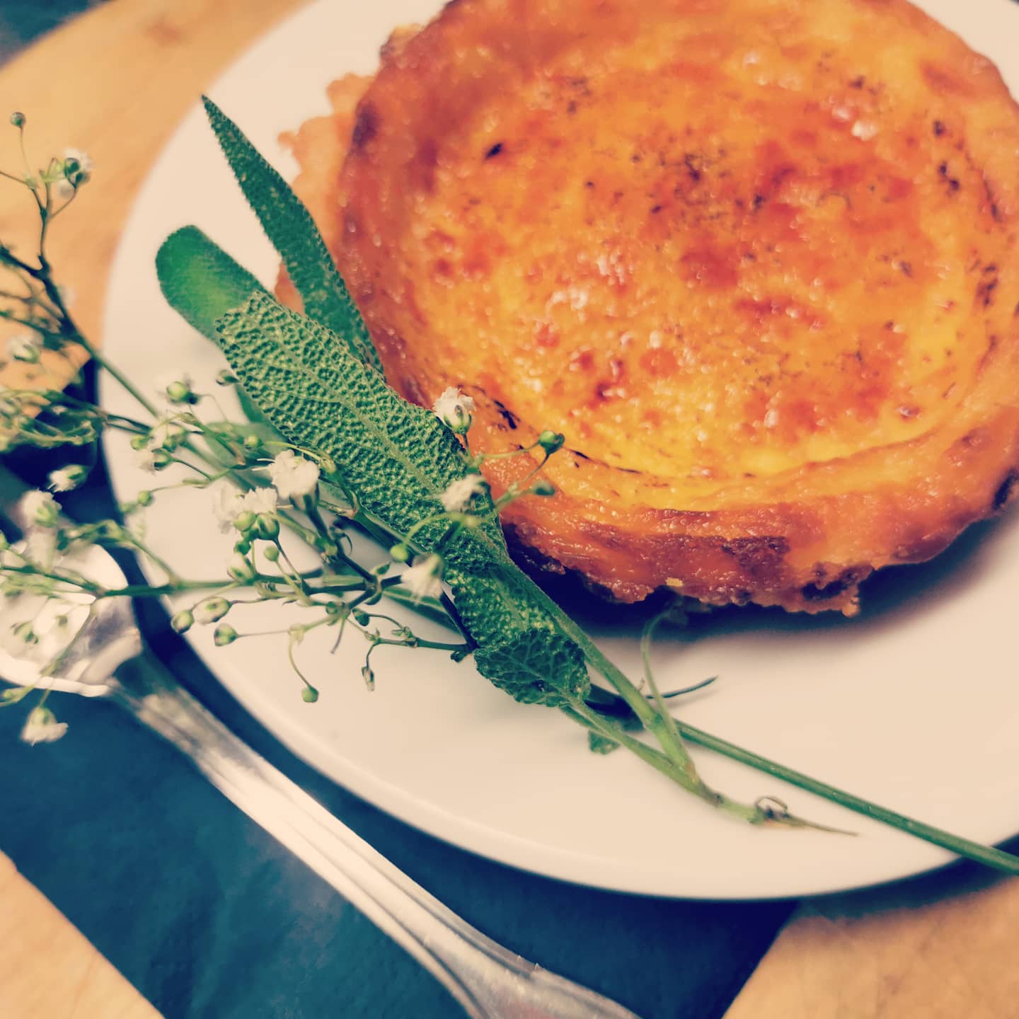 Dessert mit karamellisierter Oberfläche auf Teller mit Salbei als Garnitur auf Teller. Einkorn Dessert